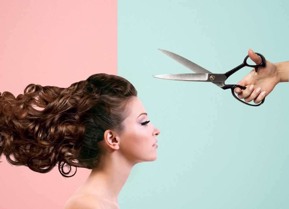 woman cutting curly hair with scissors.jpg